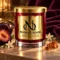 MAISON NOOR Amber Noir red glass candle with gold lid and plaque, styled with dark plum, jasmine and amber resin against plum velvet.