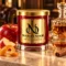 MAISON NOOR Apples and Maple Bourbon red glass candle with gold lid, styled with apple, orange peel, cinnamon, maple syrup and a crystal bourbon carafe.