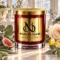 MAISON NOOR Arctic Ivy red glass candle with gold lid, styled with eucalyptus, sage, fig, lemon peel and a pale rose in a bright winter conservatory.