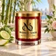 MAISON NOOR Azura red glass candle with gold lid, styled with bamboo, bergamot, apple and delicate flowers on an ivory stone pavilion table.