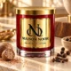 MAISON NOOR Baking Spices Element red glass candle with gold lid, styled with nutmeg, cloves and allspice on pale limestone in warm light.