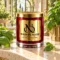 MAISON NOOR Basil Element red glass candle with gold lid, styled with fresh basil leaves on ivory travertine in a sunlit herb conservatory.
