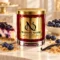 MAISON NOOR Blueberry Cheesecake red glass candle with gold lid, styled with blueberry cheesecake, blueberries, graham cracker crumbs and vanilla on ivory stone.
