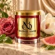 MAISON NOOR Bohemian Rose red glass candle with gold lid, styled with rose, magnolia, basil and grapefruit on ivory stone in a warm garden salon.