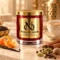 MAISON NOOR Cinnamon Chai red glass candle with gold lid, styled with creamy chai, cinnamon, cardamom, orange peel, nutmeg, cloves, peppercorns and vanilla.