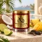 MAISON NOOR Coconut Lime red glass candle with gold lid, styled with coconut, lime, mango, pineapple and tonka beans on a tropical terrace.