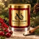 Red MAISON NOOR candle with gold lid framed by cranberries, currants, cinnamon, vanilla and evergreen sprigs.