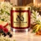 Red MAISON NOOR candle with gold lid beside elderflowers, tuberose, ylang-ylang, apple, raspberries and blackcurrants.