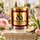 Red MAISON NOOR candle with gold lid surrounded by rose, jasmine, lilac, lily of the valley, carnation and pear in a bright conservatory.