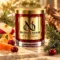 Red MAISON NOOR candle with gold lid beside apple, mandarin, cranberries, fir and juniper on ivory stone.
