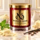 Red MAISON NOOR candle with gold lid beside white chocolate, peppermint, vanilla and cloves, with white chocolate ganache and cream behind.