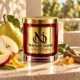 MAISON NOOR Orchard Pear candle with whole and sliced pear, apple wedge, citrus peel, sugar, resin and wood on warm limestone.