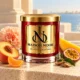MAISON NOOR Peach Mango Bellini candle with peach, mango, passionfruit, tangerine, a peach carnation and sandalwood on a coastal terrace.